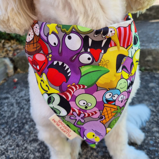Dog wearing a colorful bandana with cartoon monster characters