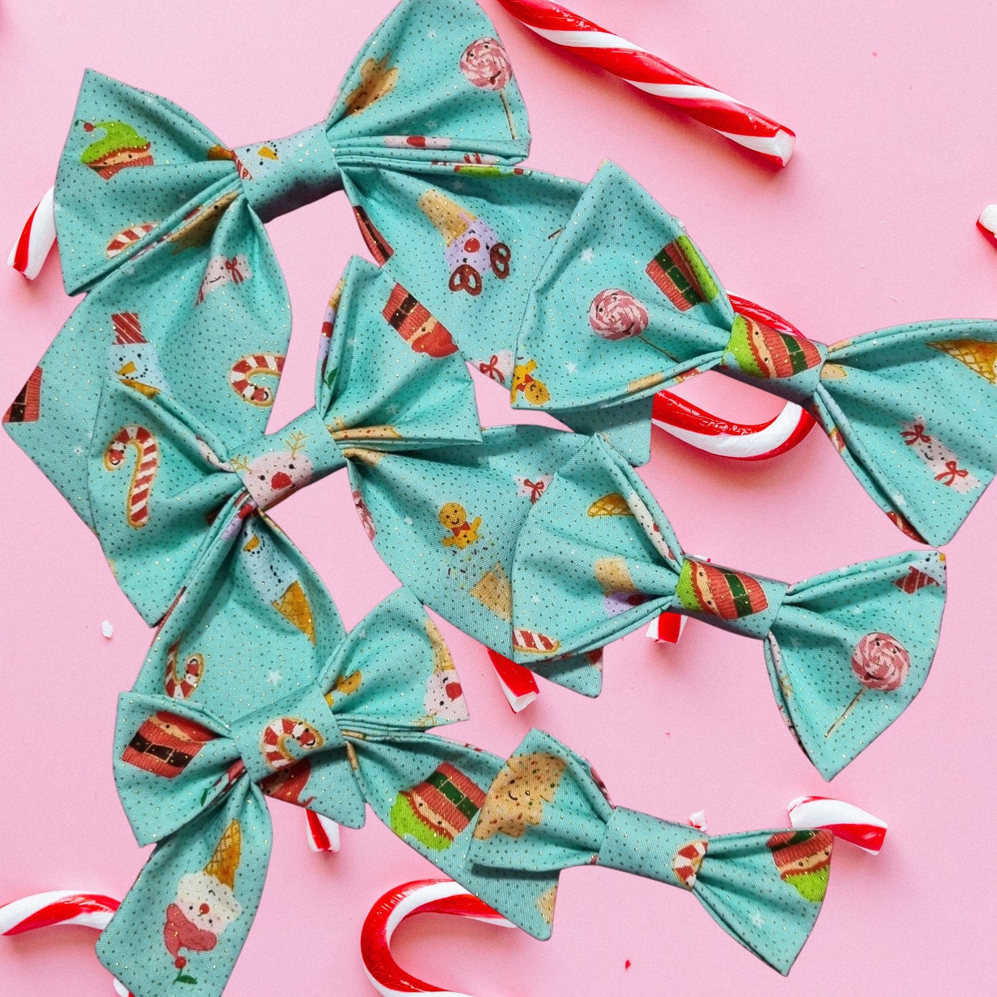 Turquoise fabric bows with Christmas patterns on a pink background